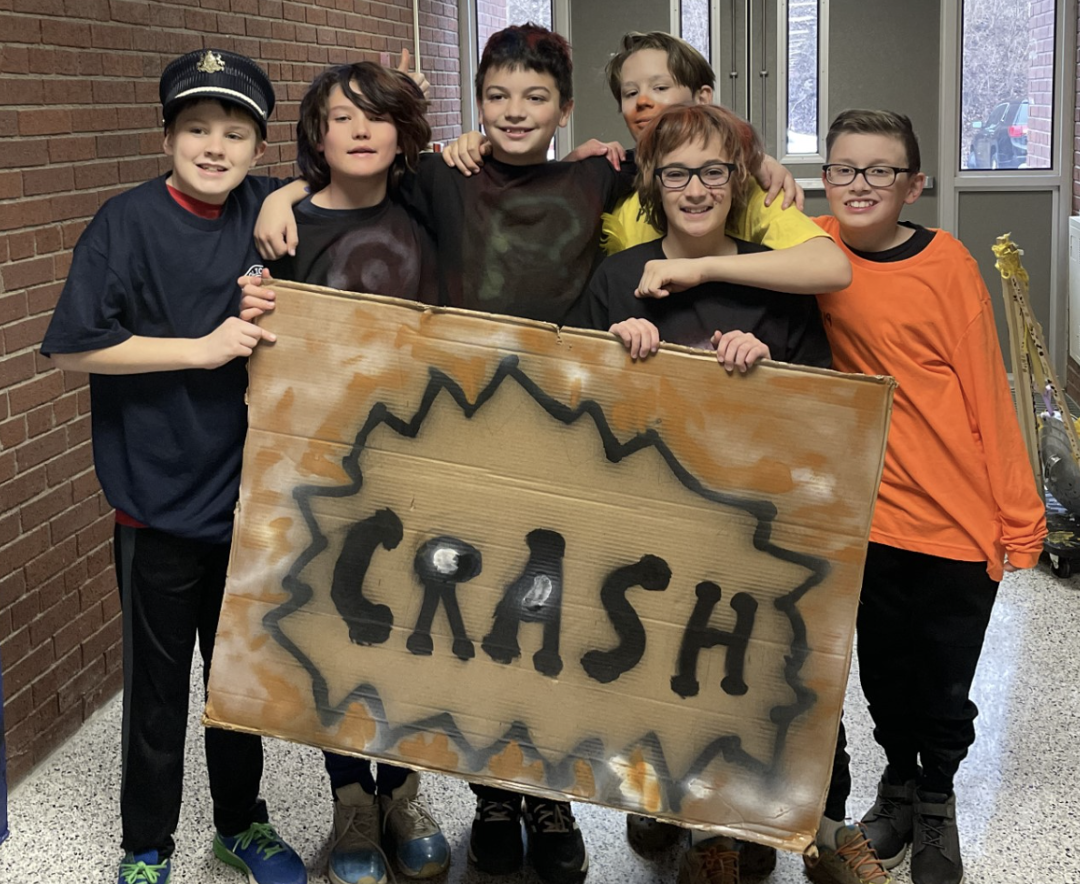 Image depicts team members JR Walsh, Declan Cottrill, Reid Forsythe, Will Keisel, Agostino Radziercz, Jack Turan, Jack Verni posing with a cardboard sign that says "CRASH."
